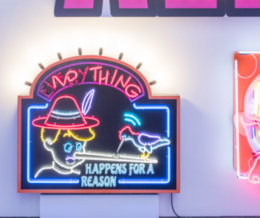 Neonkunstwerk »Everything / Nothing – happens for a reason« mit Pinocchio-Motiv in einer Ausstellung