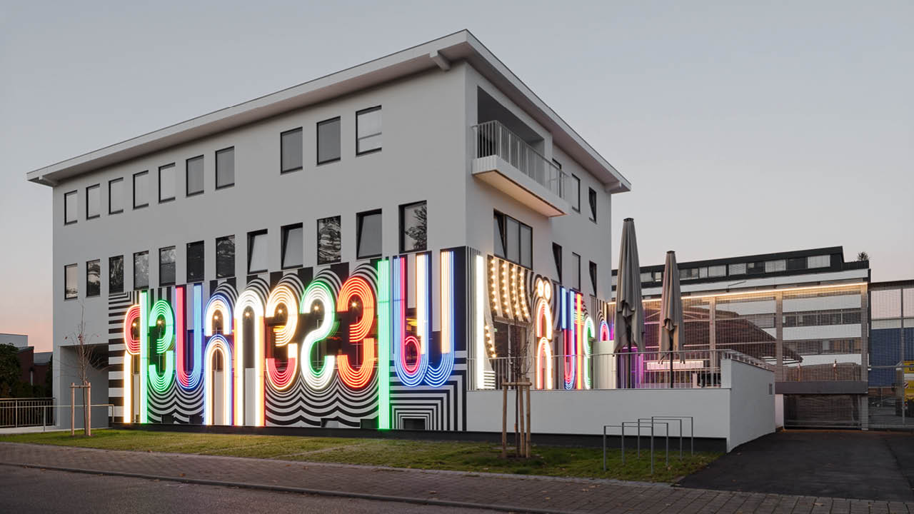 Künstlerische LED-Konturen und Schriftzüge, die sowohl im Innenraum als auch auf der Fassade für illuminierende Effekte sorgen