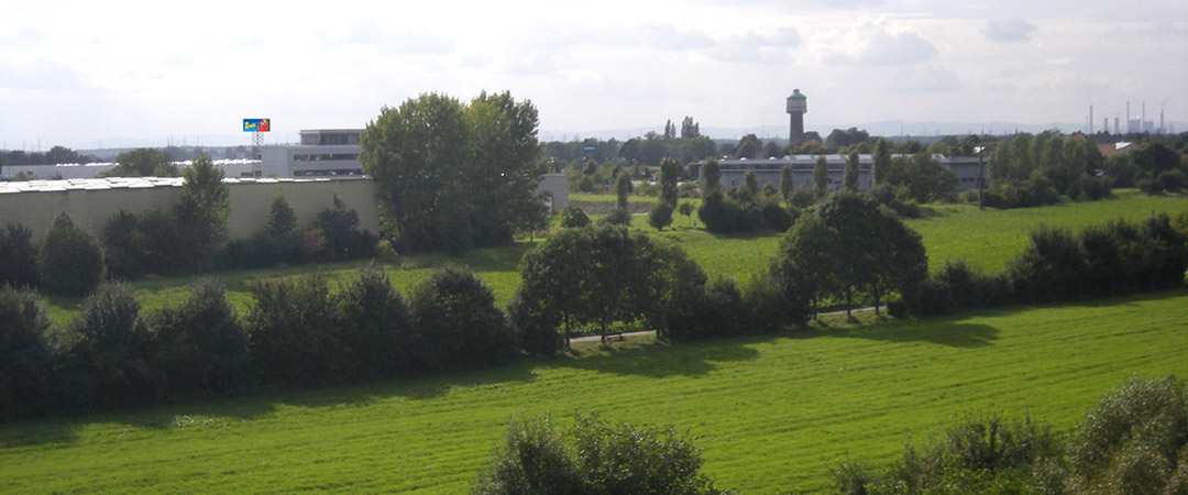 Panoramaansicht mit Tinti-Werbeanlage, die in der Ferne über einer grünen Landschaft sichtbar ist.